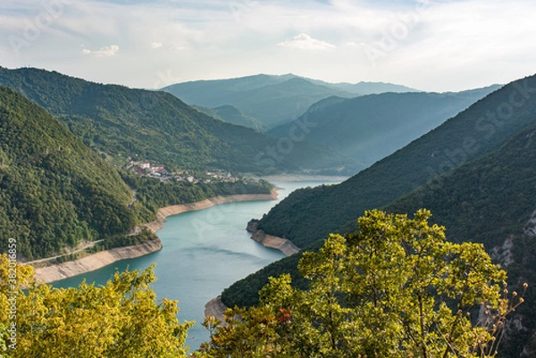 Fototapeta Lake Piva or Pivsko jezero artificial lake result of the construction of Mratinje Dam on the Piva river, Montenegro. View to Pluzine town from top of serpentine road.