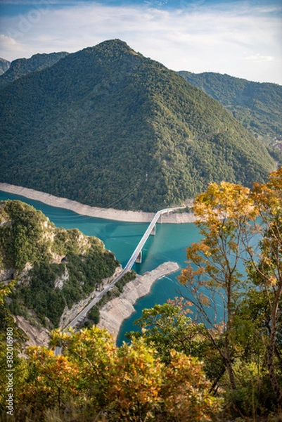 Fototapeta Lake Piva or Pivsko jezero artificial lake result of the construction of Mratinje Dam on the Piva river, Montenegro. View to Pluzine town from top of serpentine road.