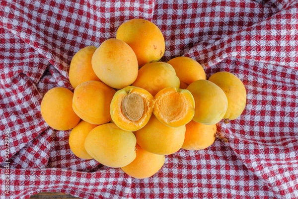 Fototapeta Apricots on a picnic cloth background. flat lay.