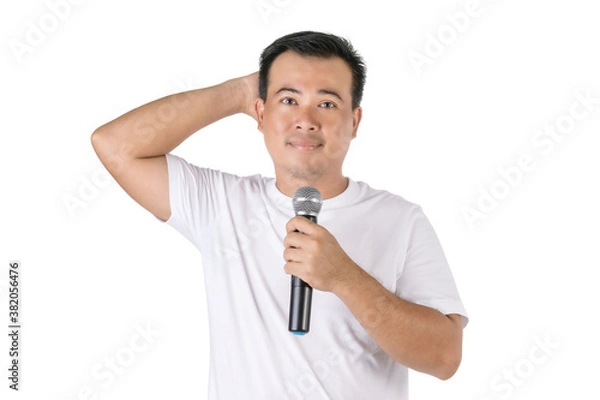 Obraz Shy or forget about speech concept. Portrait Asian man holding black wireless microphone and feel worry to speak in studio isolated on white