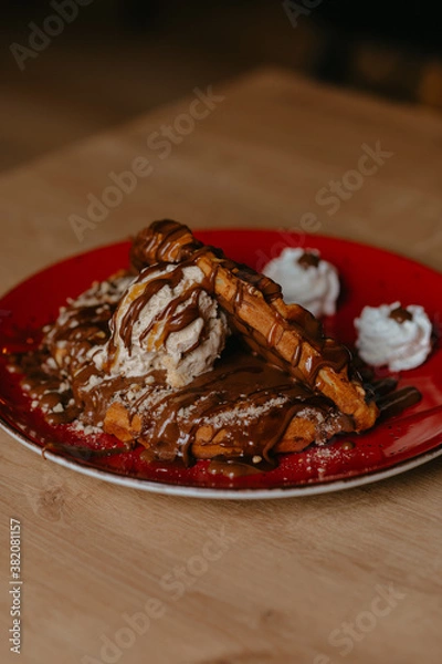 Fototapeta chocolate pancake with bananas, nuts and chocolate sauce. the toning. selective focus. a rolled chocolate pancake is a calorie bomb