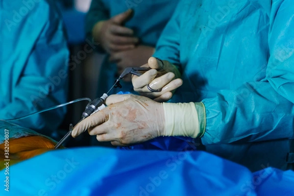 Fototapeta Medical instruments in surgeon's hands. Operating process in hospital. Doctors performing operation with surgery tools.