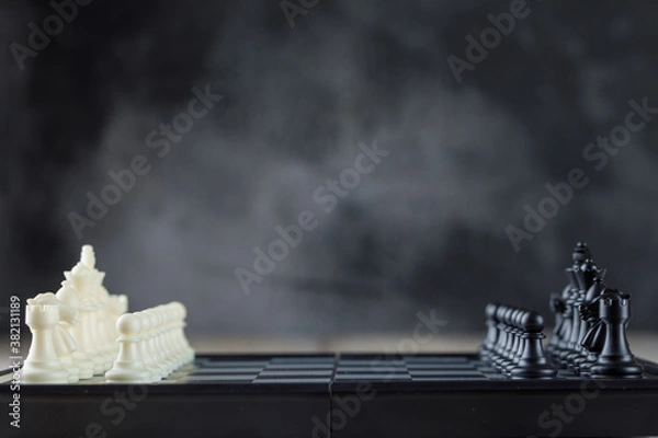 Fototapeta Business strategy concept with chessboard with figures on foggy background side view.