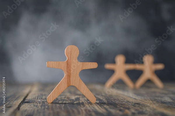 Fototapeta Business concept with wooden figures of people on wooden and foggy background side view.