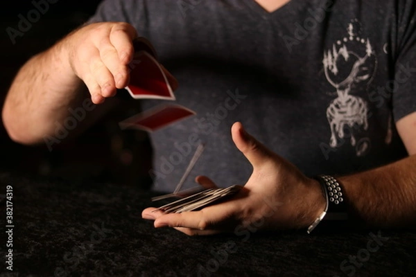 Fototapeta card magician practicing sleight of hand magic