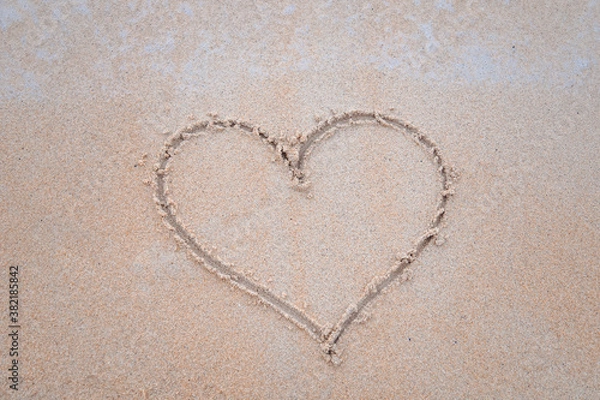 Fototapeta The sand is drawn in the shape of a heart.