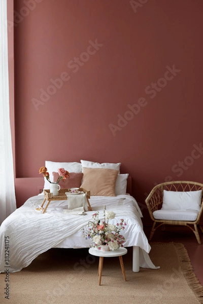 Obraz Bedroom interior of wicker armchair, bed and small wicker table on it for breakfast with a pink wall in the background