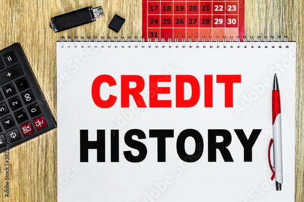 Fototapeta pen point to date on calendar with calculator and organizer book on desk. Paper with text CREDIT HISTORY