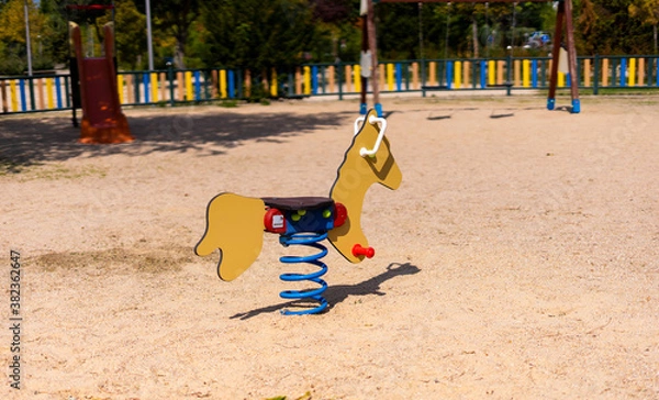 Fototapeta Top angle of a child's horse swing in an empty playground
