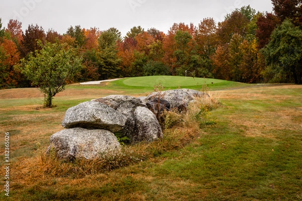 Fototapeta Granite rocks anchor the fairway on a golf course with fall leaf colors in bloom near Dedham, Maine