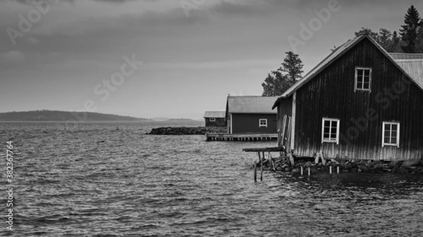 Fototapeta old broken boathouse by the sea on a cloudy day