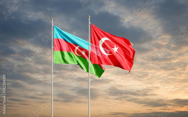 Fototapeta Azerbaijan and Turkey flags waving in the dawn sky. Symbol of international agreement and support during Karabakh war conflict with Armenia.