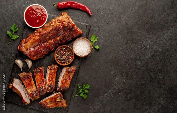 Fototapeta  grilled pork ribs with spices on a stone background with copy space for your text