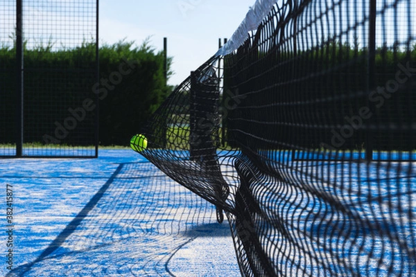 Fototapeta Paddle tennis outdoor court with the ball smashed  on the net