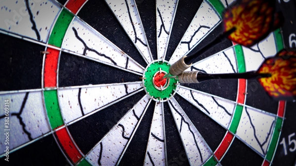 Fototapeta Dart board with arrow hitting the bullseye close up. Hitting the target