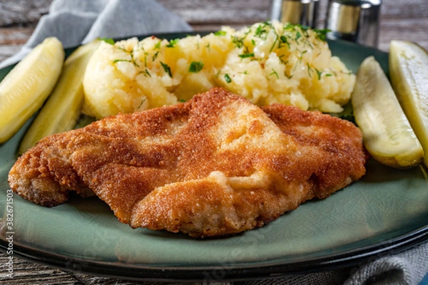 Fototapeta Pork chop served with mashed potatoes and pickled cucumber.