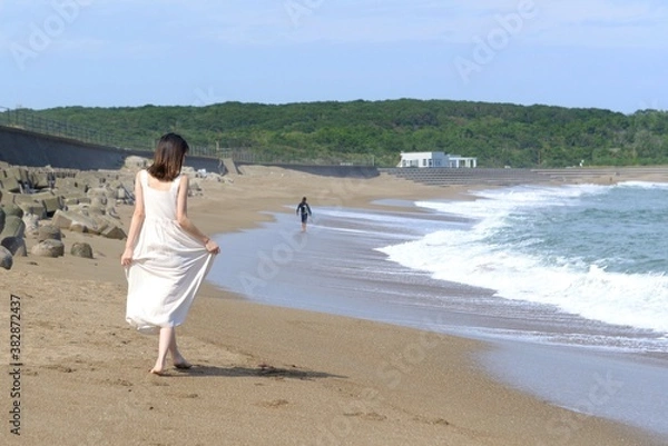 Obraz 海岸を散歩する白いワンピース姿の若い女性