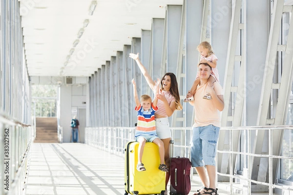 Obraz Happy family at the airport with suitcases traveling