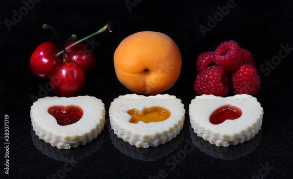 Fototapeta Christmas butter cookies with cherry and raspberry and apricot jam on black marble.