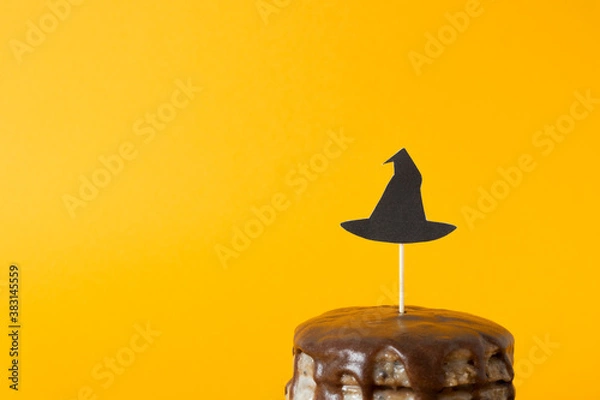 Obraz Witch hat out of paper. Halloween concept, trick or treat. Cake with decor on a stick for the holiday. ?elebration for horror. Orange background, copy space for text. Selective focus, blur.