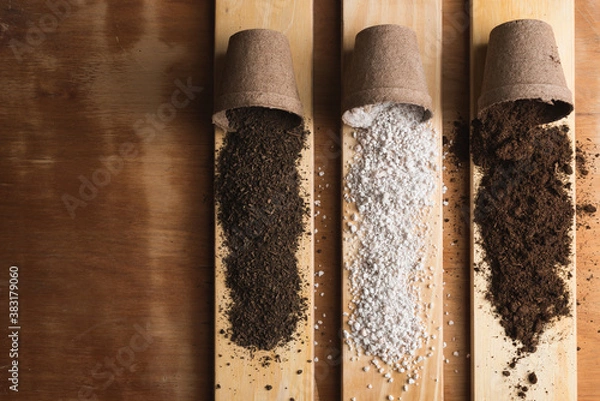 Fototapeta Peat, perlite and worm humus for soil mix on pine wood boards and a raw wooden background with space for text.