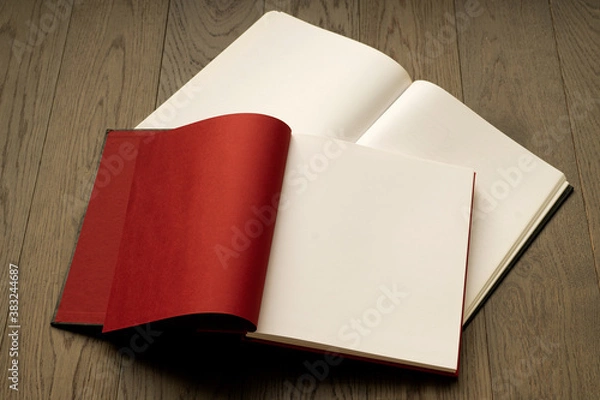 Fototapeta Open book on wooden table with red and white empty pages. Booklet, magazine mock up for any design or advertising 