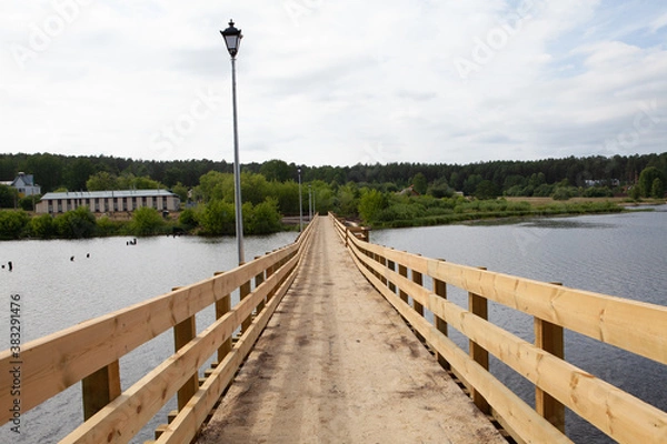 Fototapeta wooden newly built pedestrian bridge over the Sysert river