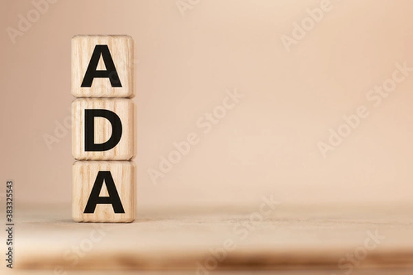 Fototapeta Word ADA Americans with Disabilities Acton wooden blocks beige background top view