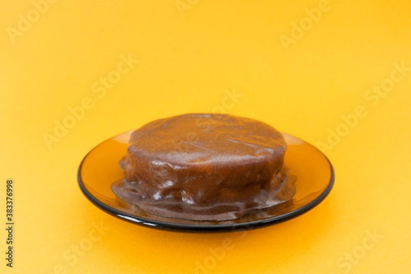 Obraz Chocolate drizzled cake on a plate. Halloween celebration concept, trick or treat. Holiday cooking, handmade brownies. Orange background, copy space. Selective focus, blur.