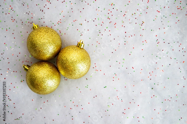 Fototapeta Three beautiful golden christmas balls on the white shiny background
