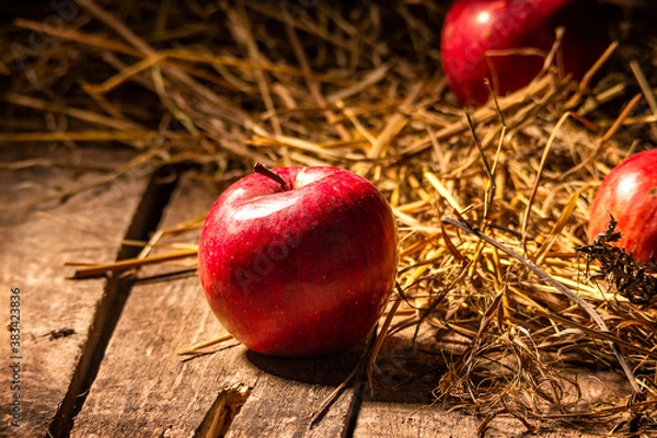 Fototapeta apples on a wooden floor on a straw mat