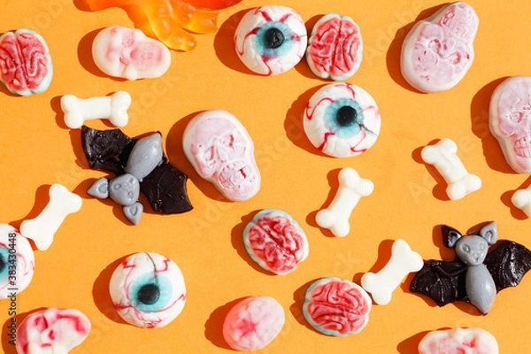 Fototapeta  marmalade in form of monster eyes, bat, brain , skull on orange background with deep shadows