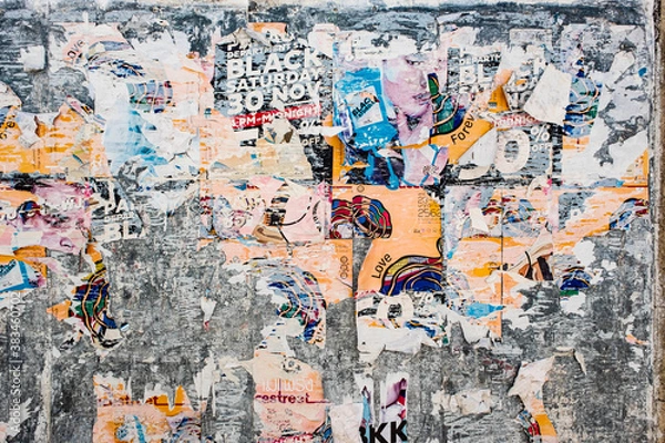 Fototapeta Texture of a bright wall with ruptures of posters and advertising. Bright abstract background