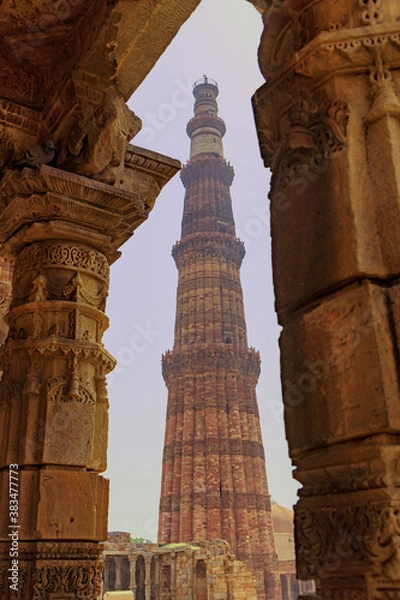 Fototapeta A view of Qutub Minar through old building pillars giving a glimpse of old archtectural heritage