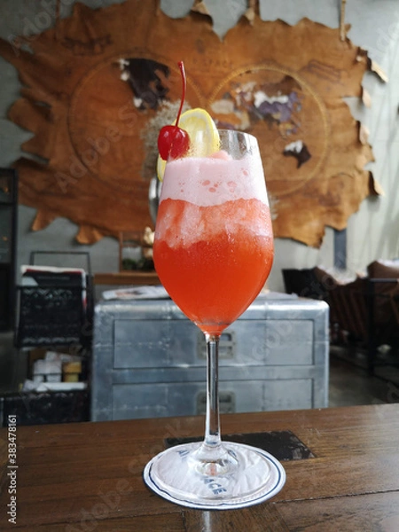 Fototapeta fruit punch iced cocktail on the wooden table with blurred background