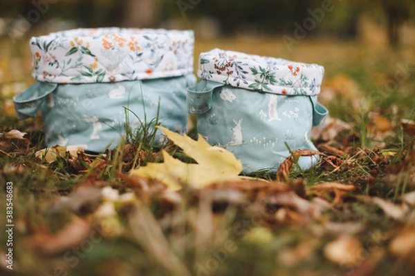 Fototapeta Empty cotton baskets or bags on the grass. close up view of autumn leaves on grass, fall time, autumn background