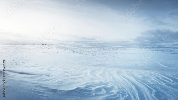Obraz Panoramic view of the snow-covered field after a blizzard at sunset. Human tracks in a fresh snow. Ice desert. Dramatic cloudscape. Global warming theme. Lapland, Finland