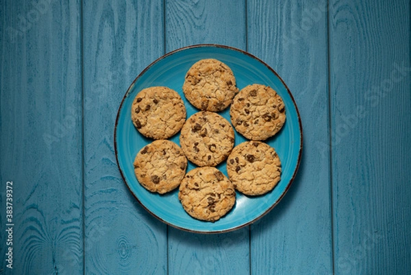 Obraz TOP VIEW: Cookies on a blue plate on a blue table