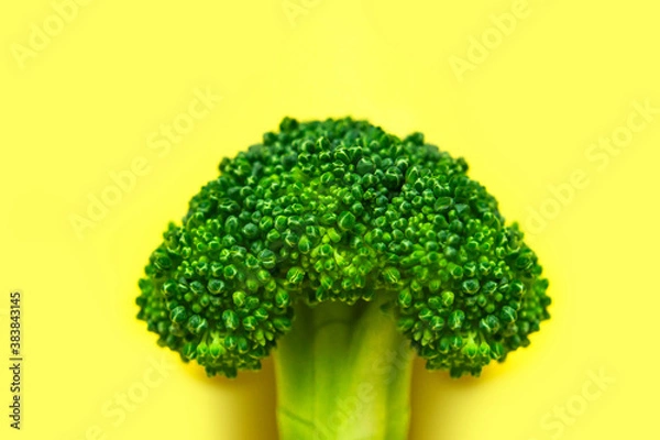 Fototapeta Creative food concept. Fresh raw green broccoli on yellow background. Healthy vegetables, diet vegan organic food, vitamins. Flat lay top view copy space. Broccoli cabbage abstract pattern