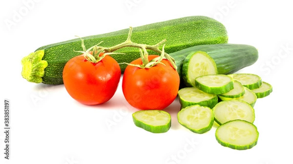 Fototapeta Sliced green cucumber, 2 red tomatos and green zucchine isolated on a white background.