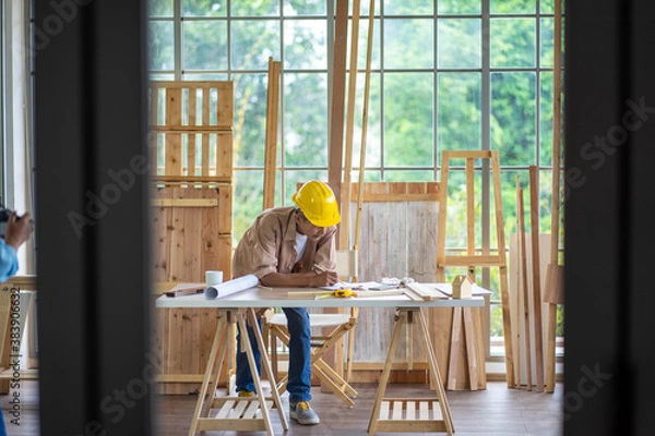 Fototapeta senior Asian man working on wood  work home improvement DIY in workshop recoding streaming online