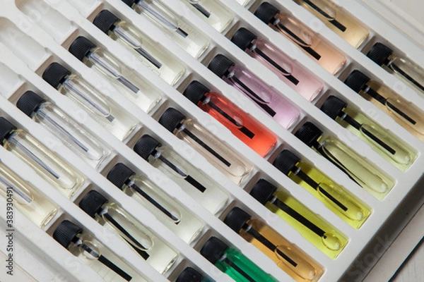 Fototapeta Sample of colored perfume bottles with different types of fragrances and aromas in a makeup case on the table. Beauty concept. Feminine concept. Colorful concept.