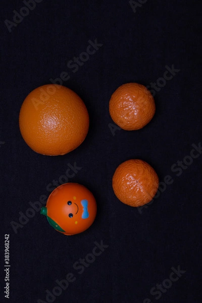 Fototapeta A set of toy oranges on a dark background. Plastic toy