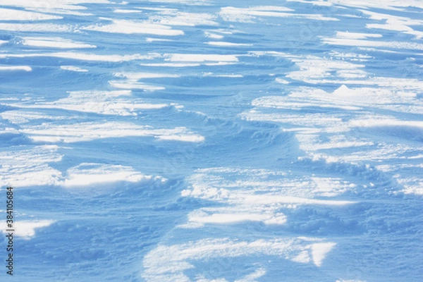 Fototapeta shady snow surface in the form of waves on a sunny day, snow texture.