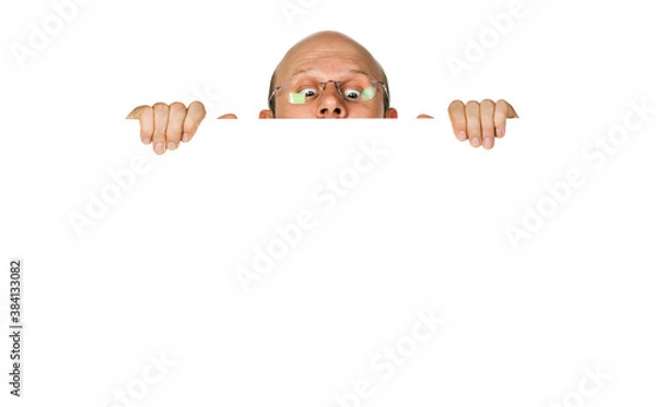 Fototapeta Portrait of curious man looking over white wall or sign. Isolate