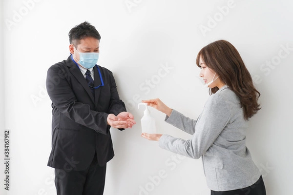 Fototapeta アルコール消毒をお願いするビジネスパーソン