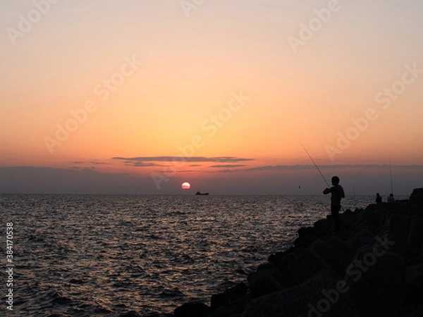 Obraz 夕日に向かって釣りをする人