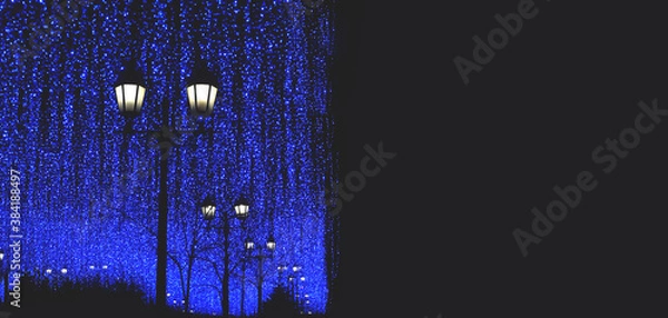 Fototapeta Christmas holiday background. A large number of lanterns and garlands on Christmas night. The concept of winter and holidays. Christmas lights. Holiday lighting. Free space for copying.