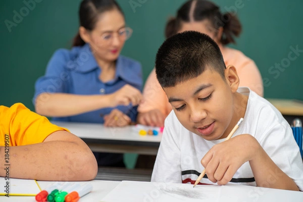 Obraz disability kid on wheelchair with Autism child in special classroom