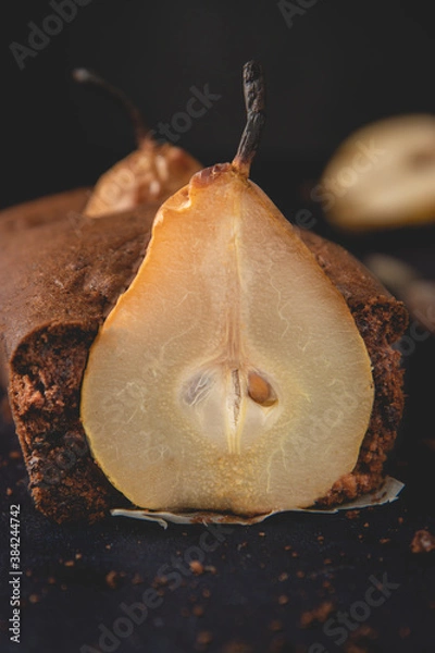 Obraz Homemade vegan chocolate cake with poached pears placed on the dark background.